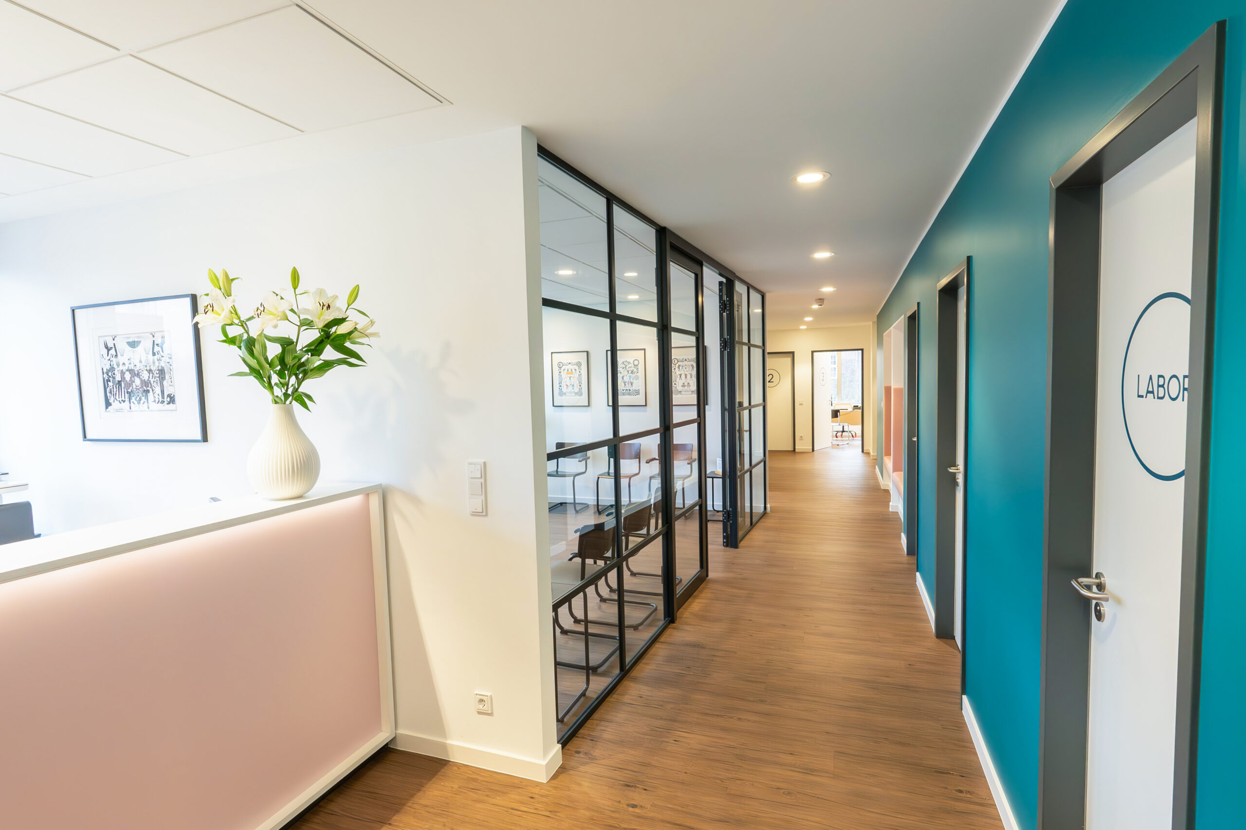 Der Flur und Empfang im Colomedicum Hamburg mit Industrie-Style Glasellementen